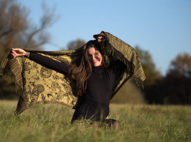 istock Elegant Woman Sitting on Grass 1286282656