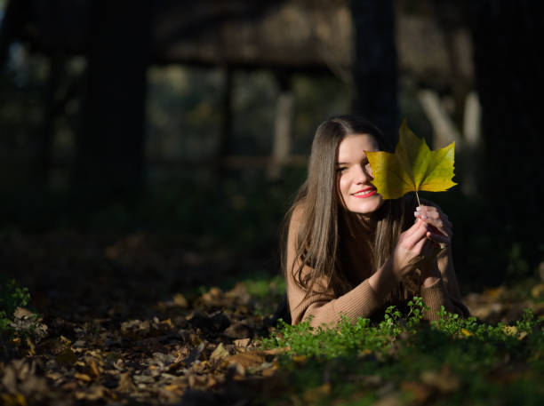 istock Woman Lie Prone in the Forest with Maple Leaf 1286282746