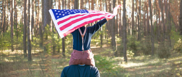 森の中でアメリカ国旗を持つ5歳の少年。憲法と愛国者の日。 - independence lifestyles smiling years ストックフォトと画像