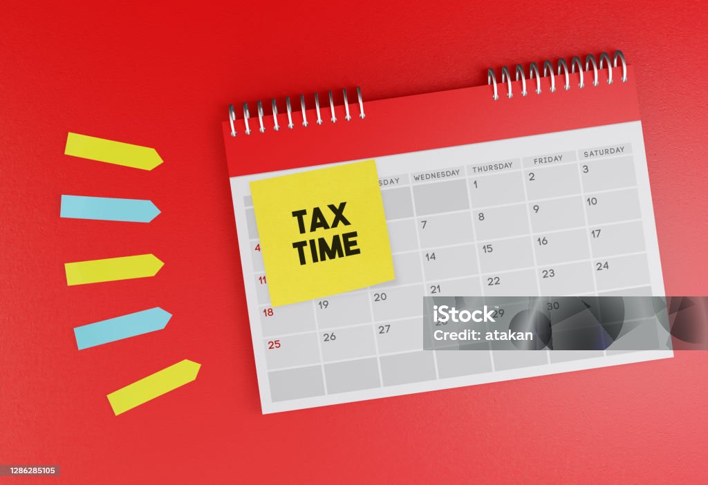 Desk calendar standing on red background. With Tax Time sticky note paper. Desk calendar standing on red background. With Tax Time sticky note paper. Horizontal composition with copy space. Tax Stock Photo