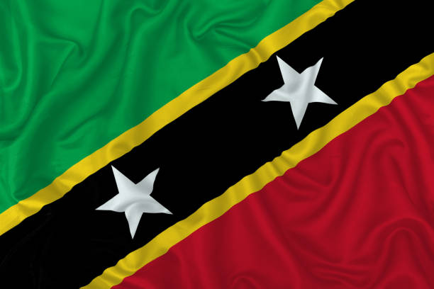 Saint Kitts and Nevis country flag on wavy silk textile fabric background.