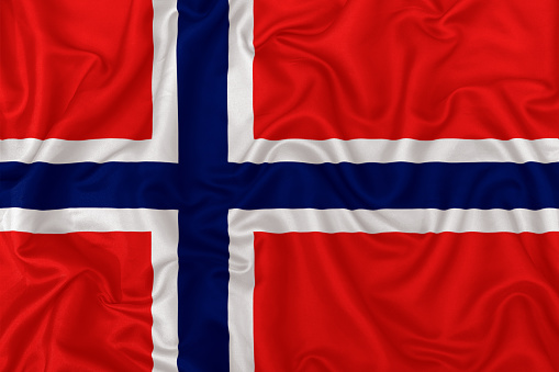 Svalbard and Jan Mayen flag on wavy silk textile fabric background.