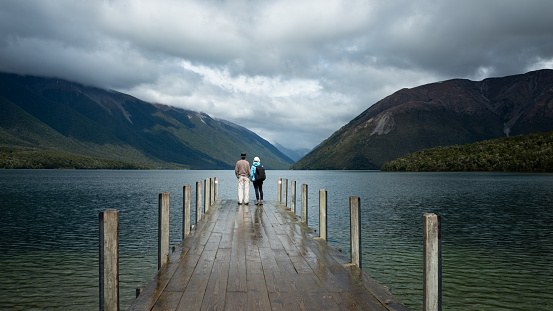 Couple standing on the lake Rotoiti wharf after the rain, Nelson Lakes National Park