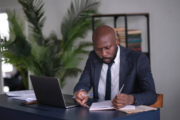 istock Thoughtful serious mixed race business analyst working with marketing statistics. pensive young african american international company employee manager working with hard task at workplace. soft focus 1286288744