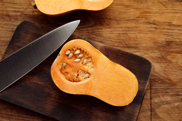 istock Pumpkin cut into halves on dark wooden table 1286288828
