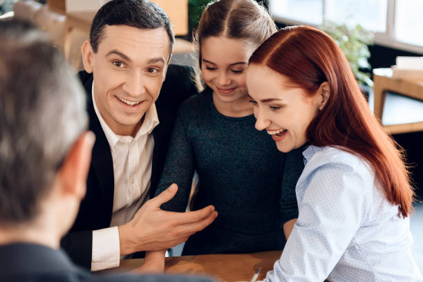 Young happy family received cash compensation for something in lawyer's office. stock photo