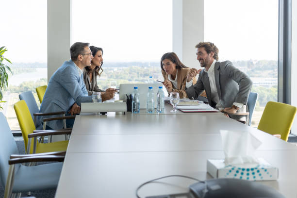 istock Management sitting at conference table and watching presentation on laptop 1286290062