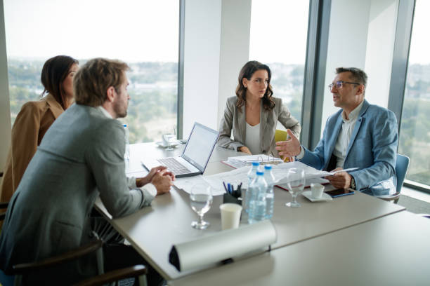 istock Businessman seriously explaining the project and holding open sheet in front of him 1286290104