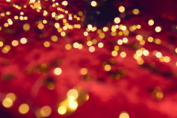 istock Blurred golden festive lights on the red background. 1286290901