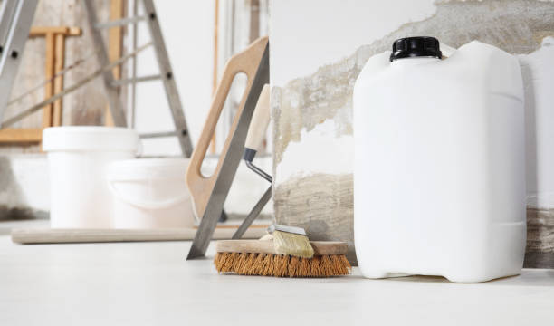 istock Indoor shot close up frontal view of bricklayer, plasterer or house painter tools on white floor with primer jerry can in home renovation site 1286292286