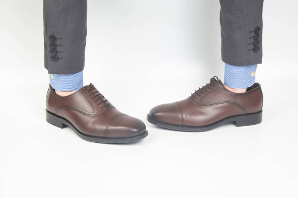 istock Classic brown men's leather shoes dressed on hands on a white background 1286293234