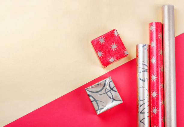 istock Golden gift boxes and red wrapping paper on bright background 1286295971