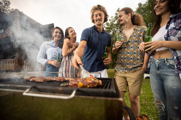istock Young guy placing the meat on the barbecue 1286296088