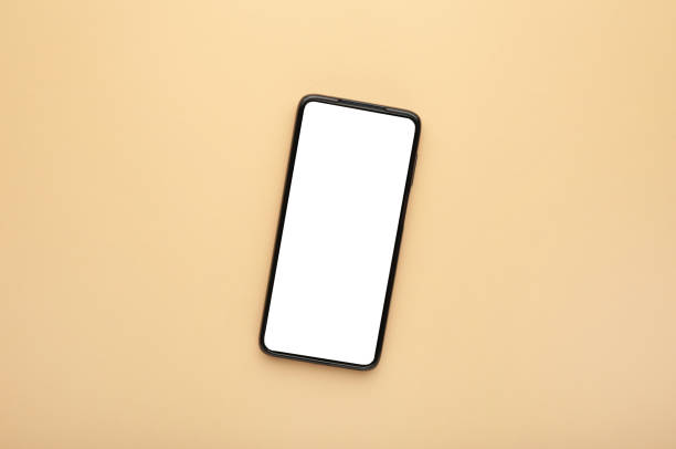 istock Black mobile smartphone with blank screen on beige background. 1286296187