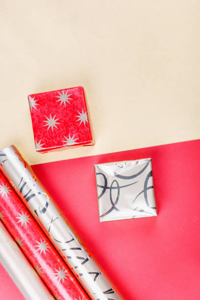istock Golden gift boxes and red wrapping paper on bright background 1286296221