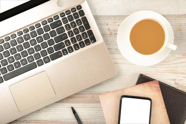 istock Laptop and coffee cup on wood table. View from above 1286296414