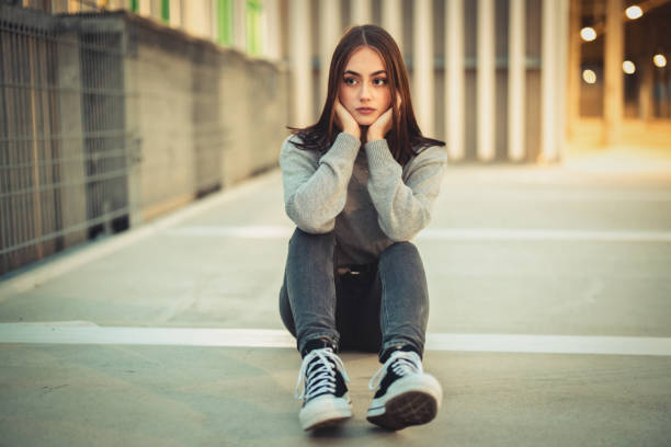 istock Young woman having problems sitting alone on concrete floor 1286297832
