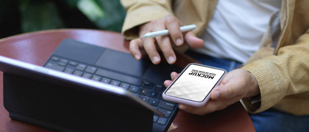 istock Male hands using smartphone on coffee table in garden 1286297851