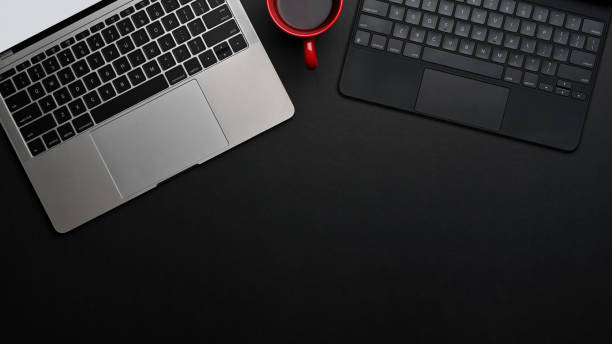 istock Top view of black table with copy space, laptop and tablet keyboard 1286297877
