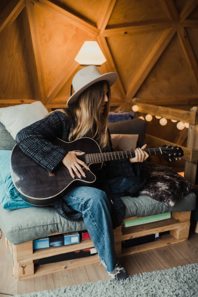 istock Young woman playing guitar 1286299141