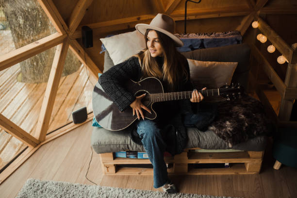 istock Young woman playing guitar 1286299220