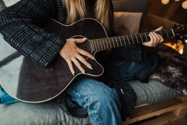 istock Young woman playing guitar 1286299318