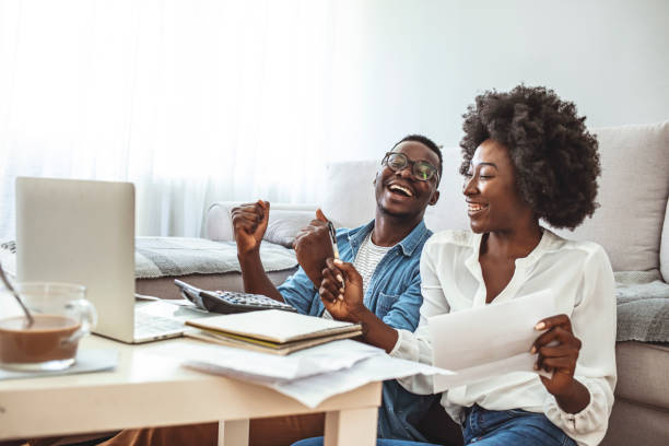 istock Happy couple at home paying bills with laptop 1286299830
