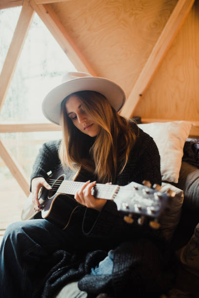 istock Young woman playing guitar 1286299917