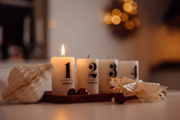 weihnachtskerzenlicht ersten advents-adventssonntag auf tisch drinnen vor demweihnachtsbaum firsta advent - advent stock-fotos und bilder