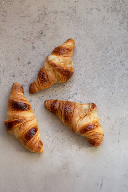 istock Freshly baked croissants on beautiful textured concrete background 1286300079