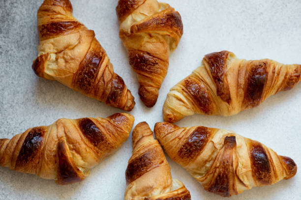 istock Freshly baked croissants on beautiful textured concrete background 1286300567