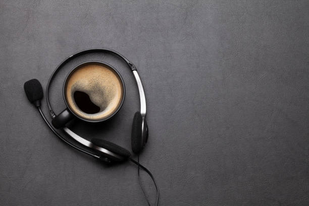 istock Office desk with headset and coffee cup 1286301681