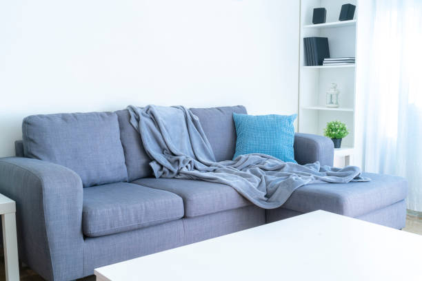 istock Modern gray couch with blanket. Copy space on the wall 1286303833