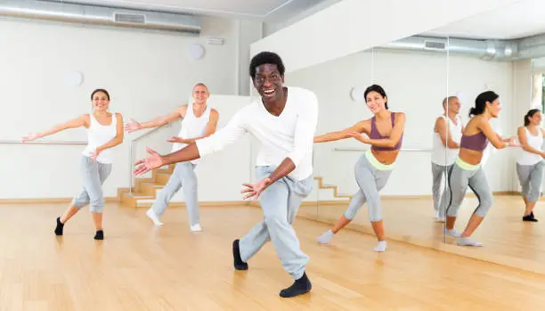 Photo of Young adult man exercising at dance class