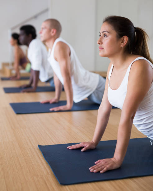 istock Young woman practicing yoga at group class 1286304045
