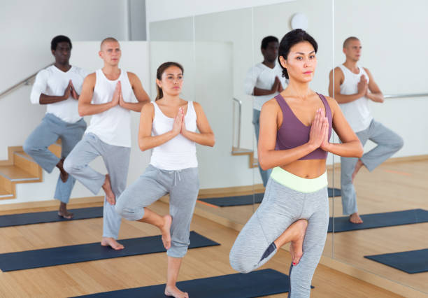 istock Multiethnic group of young people practicing yoga 1286304355