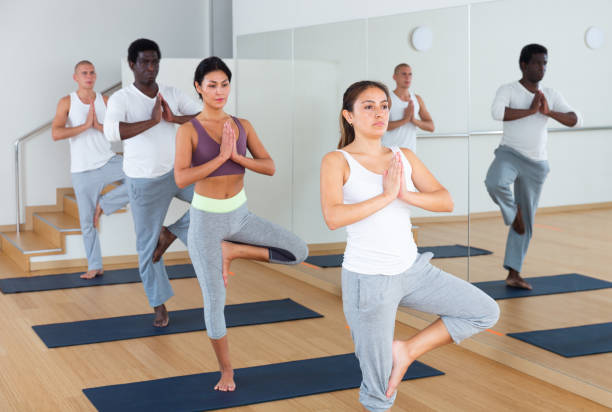 istock Women and men performing yoga exercises during group training 1286304365