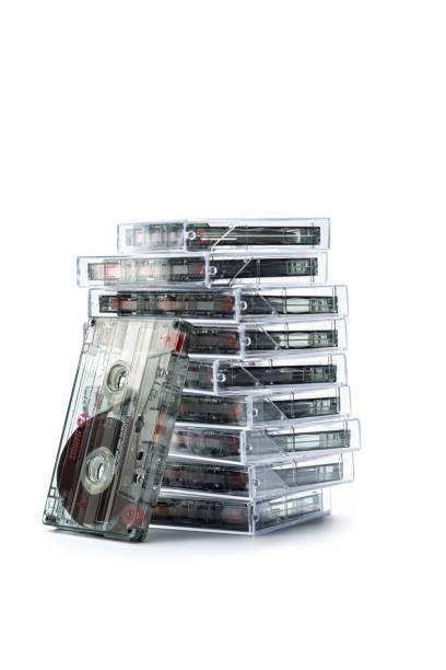 Stack of  cassette tapes, isolated on white. Stack of  cassette tapes, isolated on white in their plastic cases.   One stands upright against the stack. Selective focus.Shot with a tilt shift lens. walkman cassette stock pictures, royalty-free photos & images
