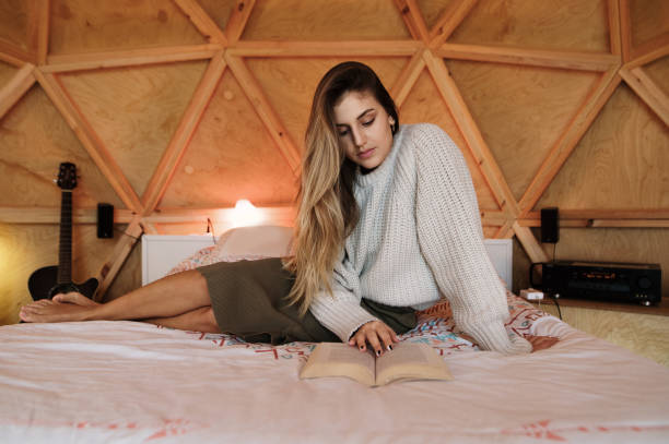 istock Young woman reading and lying on bed 1286307844