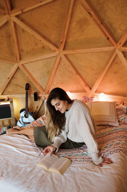 istock Young woman reading and lying on bed 1286308795