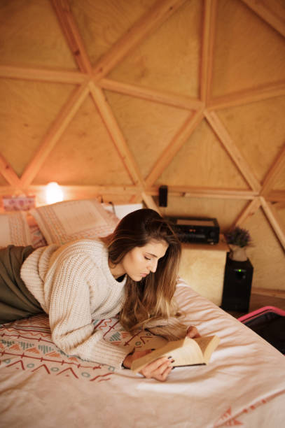 istock Young woman reading and lying on bed 1286308957
