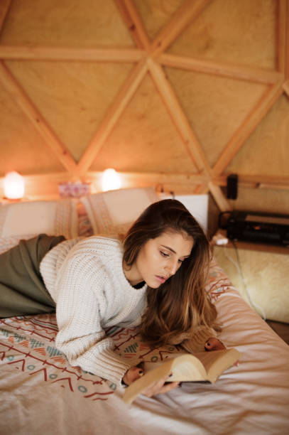 istock Young woman reading and lying on bed 1286309034