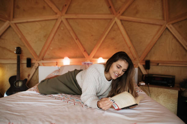 istock Young woman reading and lying on bed 1286309035