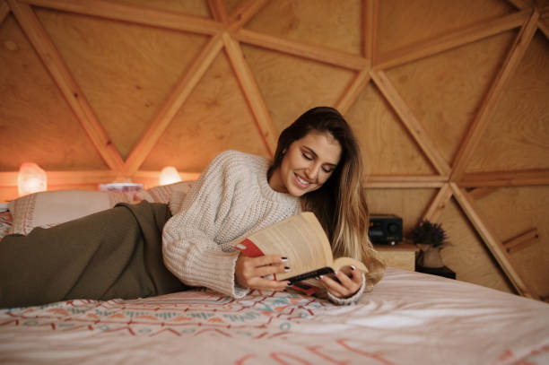 istock Young woman reading and lying on bed 1286310043