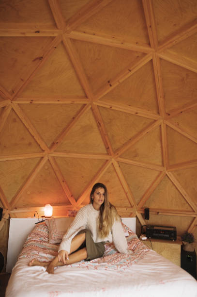 istock Young woman lying on bed inside a wooden dome 1286310050