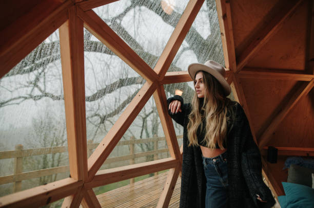 istock Young woman looking through the window 1286312013
