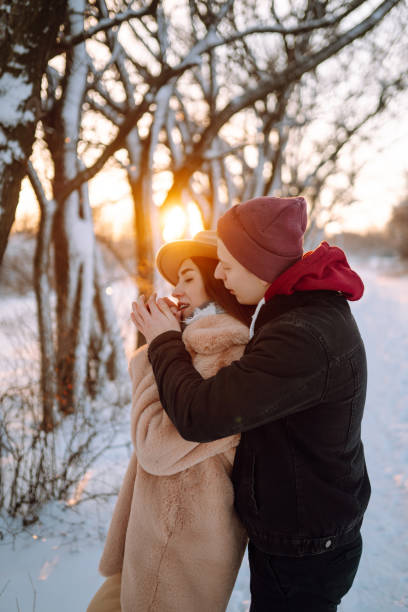 istock Young couple hugging and laughing outdoors in winter at sunset. 1286312698