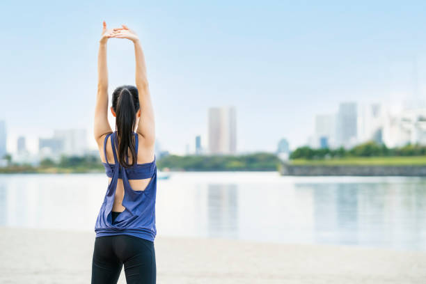 若い女性が伸びて深呼吸をする - relaxation exercise stretching exercising women ストックフォトと画像