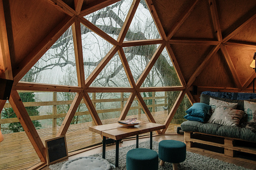 Inside view of a wooden dome with a beautiful design in a forest