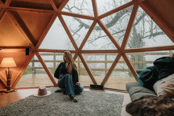 giovane donna all'interno di una cupola di legno - house residential structure building exterior comfortable foto e immagini stock